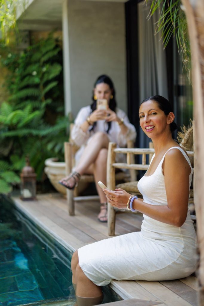 Nedjma au bord de la piscine, téléphone à la main